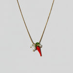 Necklace with red and green pendant on a beige background