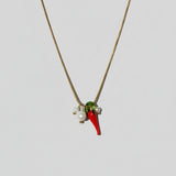 Necklace with red and green pendant on a beige background